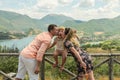 Mom and Dad kiss their daughter on the background of a mountain lake Lago del Turano - happy family