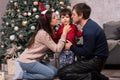 Mom and dad kiss a young son near the Christmas tree. Happy New Year`s morning with the family. Parents and child Royalty Free Stock Photo