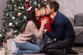 Mom and dad kiss a young son near the Christmas tree. Happy New Year`s morning with the family. Parents and child Royalty Free Stock Photo