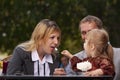 Mom, dad, little daughter eat iice cream. A young family came together in a cafe. Happy family lunch concept