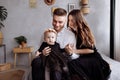 Mom, dad and little girl having fun and hugging at home on bed. mother`s, father`s and baby`s day. Happy family holiday indoors Royalty Free Stock Photo