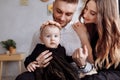 Mom, dad and little girl having fun and hugging at home on bed. mother`s, father`s and baby`s day. Happy family holiday indoors Royalty Free Stock Photo