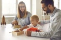 Mom, dad and little son playing with toys and educational games sitting at table at home Royalty Free Stock Photo