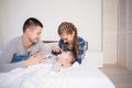 Mom dad and son in the morning lying on the bed at home in the morning play Royalty Free Stock Photo