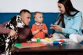 mom, dad, son and their dog play with plasticine and paint at home Royalty Free Stock Photo