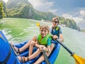 Mom, dad and son travelers rowing on a kayak in Halong Bay. Vietnam. Travel to Asia, happiness emotion, summer holiday