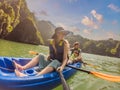 Mom, dad and son travelers rowing on a kayak in Halong Bay. Vietnam. Travel to Asia, happiness emotion, summer holiday