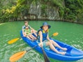 Mom, dad and son travelers rowing on a kayak in Halong Bay. Vietnam. Travel to Asia, happiness emotion, summer holiday