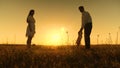 Mom and dad are taught to go to small daughter, young beautiful family in park with a child at sunset Royalty Free Stock Photo