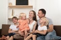 Mom dad and three children are sitting together on couch. Big friendly family Royalty Free Stock Photo