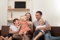 Mom dad and three children are sitting together on couch. Big friendly family Royalty Free Stock Photo