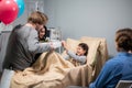 Mom and dad visiting their little girl at the hospital, they brought her a present, she is very happy Royalty Free Stock Photo