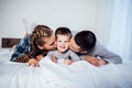 Mom dad and son in the morning lying on the bed at home in a good mood Royalty Free Stock Photo