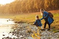 Mom with daughter in autumn. Mother and daughter walking near river in autumn time. Happy family. Fall weekend in the open air. Fa