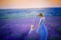 Mom and daughter in beautiful dresses in lavender field