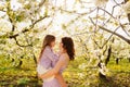 mom and daughter. family in purple clothe in blossoming spring garden. Royalty Free Stock Photo