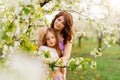 A mom and daughter in a blossoming spring garden. natural cosmetics