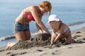 Mom and daughter are building a sand castle