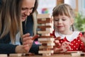 Mom and daughter are building wooden blocks table