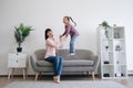 Mom-daughter duo testing bounce of couch in family lounge Royalty Free Stock Photo