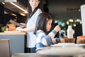 Mom and daughter eating Cereals with milk having breakfast in kitchen.