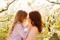 mom and daughter. family in purple clothe in blossoming spring garden. Royalty Free Stock Photo