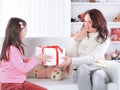 Mom and daughter with gift box sitting on the couch.the concept of surprise