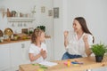 Mom and daughter are happy to finish their homework in the kitchen. Home life. Real joy Royalty Free Stock Photo