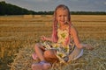 Mom And Daughter In A Harvested Wheat Field During Sunset.