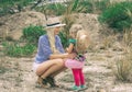 Mom and daughter in hats. Beautiful blond woman wearing hat outdoors on prairie. Royalty Free Stock Photo