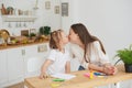 Mom and daughter have finished doing their homework, are happy and kiss. The concept of taking care of a child and