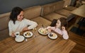 Mom and daughter having lunch together at a restaurant in the airport departure terminal while waiting to board the flight. Royalty Free Stock Photo