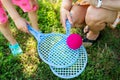 Mom and daughter holding blue rackets with a pink ball outdoors on a sunny day. Royalty Free Stock Photo