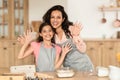 Mom and daughter joyfully showing hands in flour in kitchen Royalty Free Stock Photo