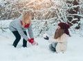 Mom and daughter make snowman from white snow Royalty Free Stock Photo