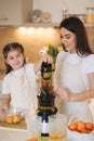 Mom and daughter making homemade healthy juice. Organic fruits and vegetables. Vegan beverage Royalty Free Stock Photo