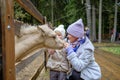 Mom and daughter caress the face of a foal at the petting zoo. Royalty Free Stock Photo