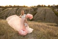 Mom with daughter in pink fairy-tale dresses walk in nature. The childhood of the little princess. Large pink decorative flowers