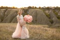 Mom with daughter in pink fairy-tale dresses walk in nature. The childhood of the little princess. Large pink decorative flowers