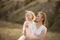 Mom with daughter in pink fairy-tale dresses walk in nature. Little princess childhood