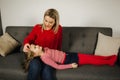 Mom and daughter play at home. Little girl tickle her mother. Happy family spend time together. Blond hair woman Royalty Free Stock Photo