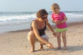 Mom and daughter plays on the beach Royalty Free Stock Photo