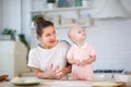 Mom and daughter prepare dough for pies in a bright kitchen and play with each other Royalty Free Stock Photo