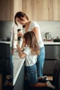 Mom and daughter prepare icing for gingerbread in their home kitchen. Beat with a blender. The girl helps the woman. Royalty Free Stock Photo