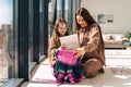 Mom and daughter prepare school backpack.