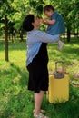 Mom and daughter are preparing for the trip. A little girl sits on a yellow suitcase suitcase. Go on a trip, relax at sea, collect Royalty Free Stock Photo