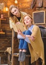 Mom and daughter reading together. Woman wrapped in woolen blanket holding book. Mother helping teenage child with Royalty Free Stock Photo