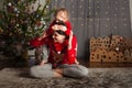 Mom and daughter in a red sweater for Christmas at the Christmas tree. A girl and her mother are hugging, kissing at the Christmas Royalty Free Stock Photo