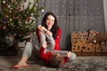 Mom and daughter in a red sweater for Christmas at the Christmas tree. A girl and her mother are hugging, kissing at the Christmas Royalty Free Stock Photo