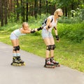 Mom and daughter ride on roller skates Royalty Free Stock Photo